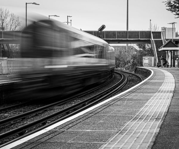 A grayscale shot of a train caught in motion