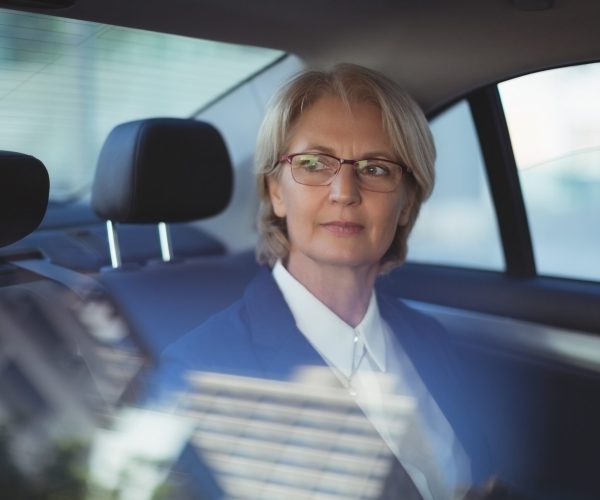 Thoughtful businesswoman looking away while traveling in car