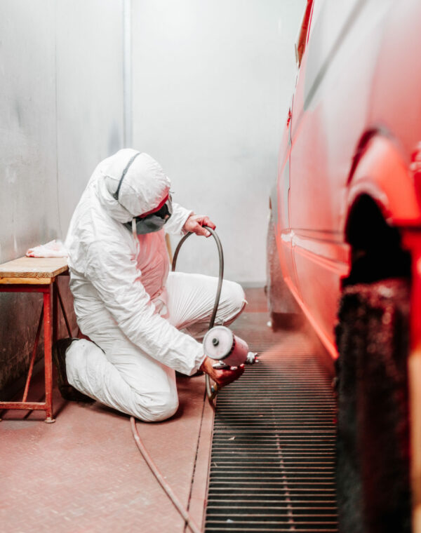 close up details of industrial worker, mechanic engineer painter using a spray brush gun and painting a car